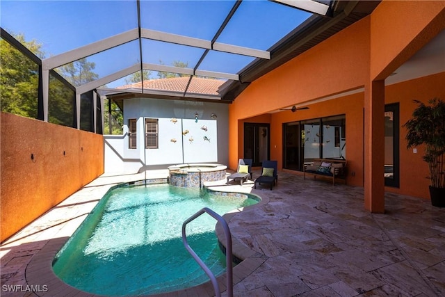 view of pool with a patio area, glass enclosure, a pool with connected hot tub, and a ceiling fan