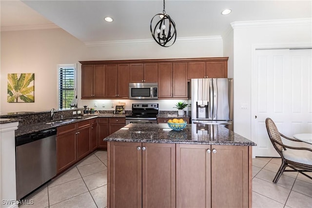 8295 Provencia Ct, Fort Myers, FL 33912 - kitchen featuring appliances with stainless steel finishes, a sink, light tile patterned flooring, dark stone counters, and a center island