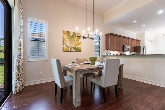 dining area featuring dark wood finished floors, a healthy amount of sunlight, and ornamental molding