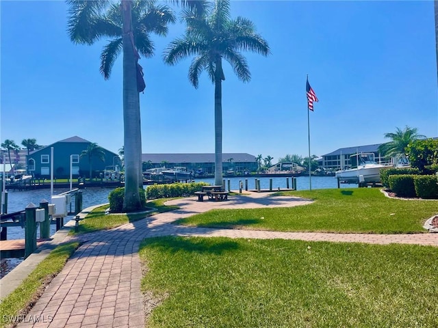4703 SE 17th Pl Unit 105, Cape Coral, FL 33904 - view of community featuring a yard, a boat dock, and a water view