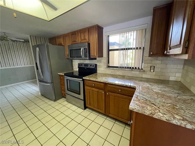4703 SE 17th Pl Unit 105, Cape Coral, FL 33904 - kitchen with appliances with stainless steel finishes, light tile patterned floors, tasteful backsplash, and brown cabinets