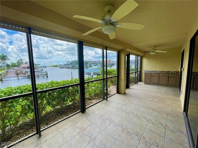 4703 SE 17th Pl Unit 105, Cape Coral, FL 33904 - unfurnished sunroom featuring a water view, ceiling fan, and plenty of natural light