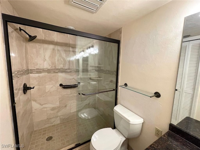 4703 SE 17th Pl Unit 105, Cape Coral, FL 33904 - bathroom with toilet, a shower stall, a closet, and a textured wall