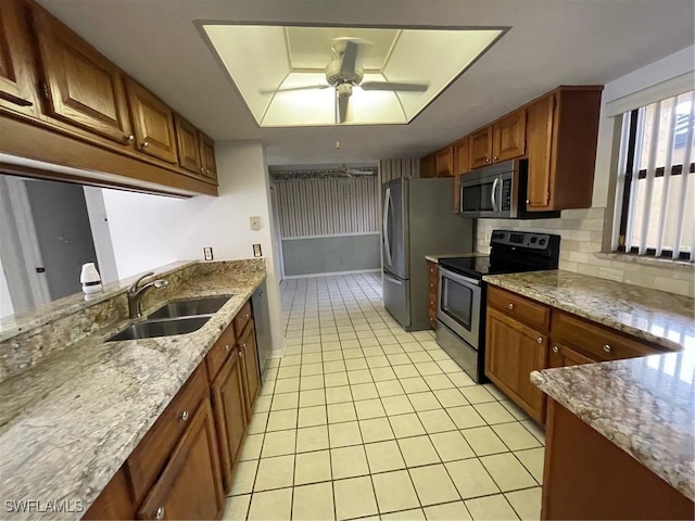 4703 SE 17th Pl Unit 105, Cape Coral, FL 33904 - kitchen featuring appliances with stainless steel finishes, a sink, light tile patterned flooring, ceiling fan, and light stone counters
