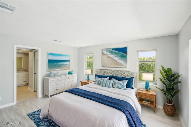 bedroom featuring visible vents, multiple windows, and light wood-style floors