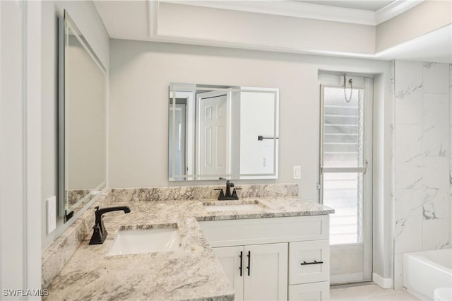 bathroom featuring double vanity, a bath, crown molding, and a sink