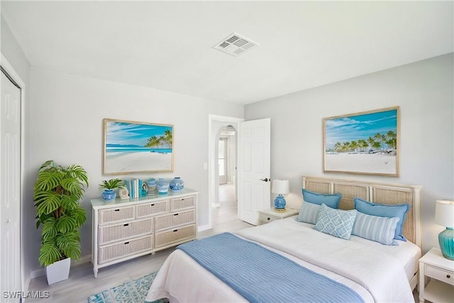 bedroom with visible vents, baseboards, and wood finished floors