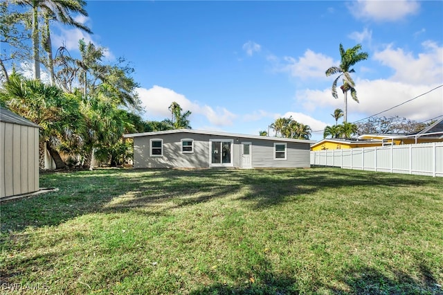 944 22nd Ave N, Naples, FL 34103 - back of house with an outbuilding, fence, a lawn, and a shed