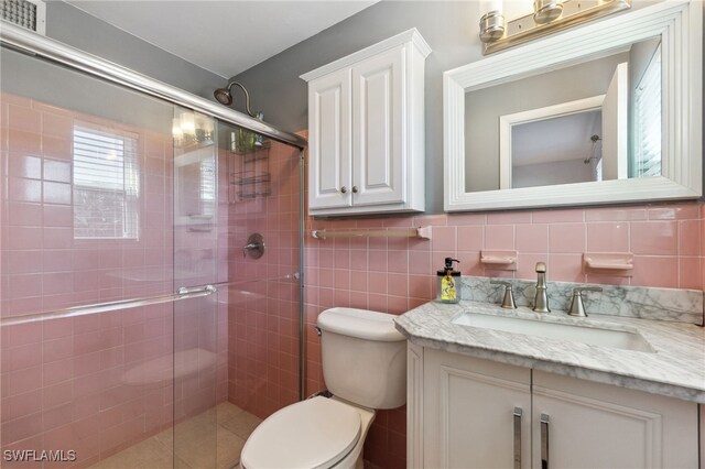 944 22nd Ave N, Naples, FL 34103 - full bath featuring visible vents, toilet, tile walls, a shower stall, and vanity