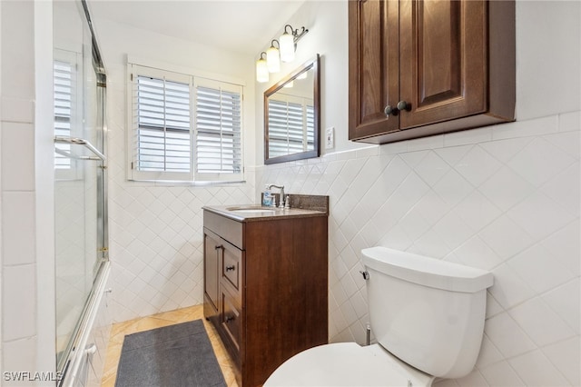 944 22nd Ave N, Naples, FL 34103 - full bath with vanity, an enclosed shower, wainscoting, tile walls, and toilet