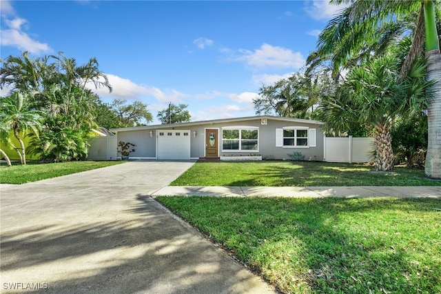 944 22nd Ave N, Naples, FL 34103 - view of front of house featuring stucco siding, driveway, a front lawn, fence, and a garage