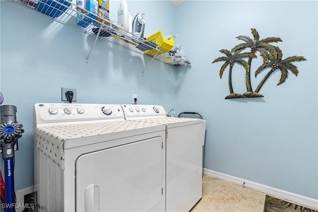 washroom with tile patterned flooring, laundry area, baseboards, and washer and clothes dryer