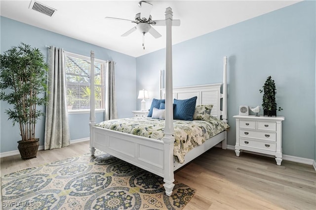 bedroom featuring baseboards, visible vents, light wood finished floors, and ceiling fan