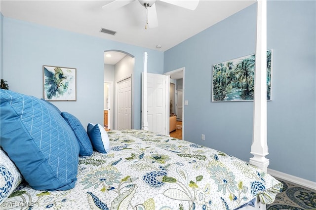 bedroom with a ceiling fan, visible vents, ensuite bath, arched walkways, and a closet