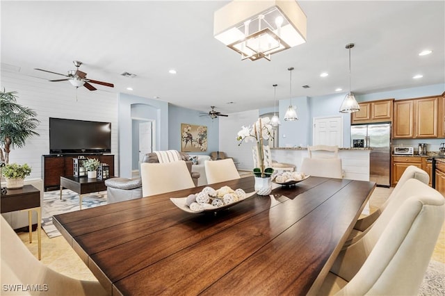 dining space with a toaster, recessed lighting, ceiling fan with notable chandelier, and visible vents