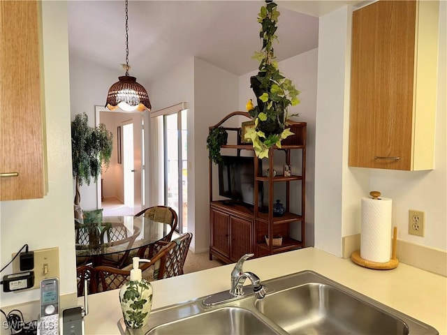 kitchen featuring a sink, hanging light fixtures, and light countertops