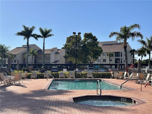 view of pool featuring a patio, a community hot tub, and fence