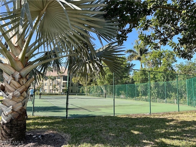 view of tennis court featuring fence