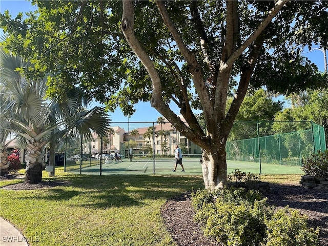 view of sport court with a yard and fence