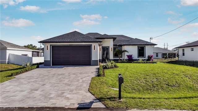 view of front of home with stucco siding, a front yard, and fence