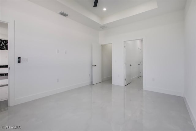 interior space featuring a raised ceiling, recessed lighting, visible vents, and baseboards