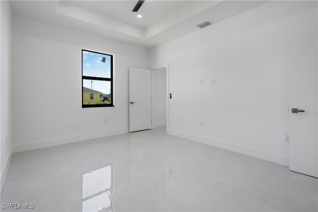 spare room with visible vents, recessed lighting, a raised ceiling, and baseboards