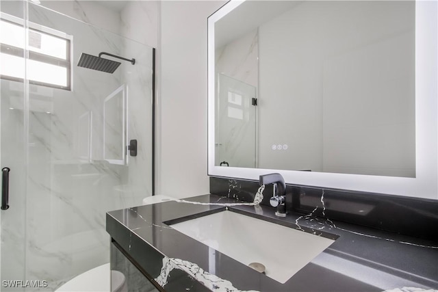 bathroom featuring vanity, toilet, and a marble finish shower