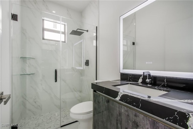 full bath with vanity, toilet, and a marble finish shower