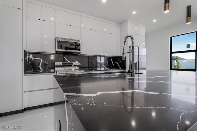 kitchen with modern cabinets, a sink, stainless steel appliances, white cabinets, and decorative backsplash