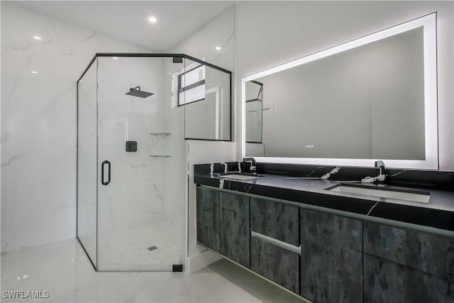 bathroom featuring double vanity, a marble finish shower, and a sink