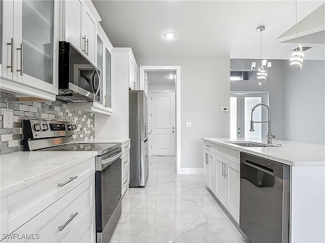 650 Kraft St, Lehigh Acres, FL 33974 - kitchen featuring appliances with stainless steel finishes, a sink, light marble finish floors, tasteful backsplash, and white cabinets
