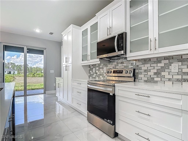 650 Kraft St, Lehigh Acres, FL 33974 - kitchen featuring electric range, light countertops, backsplash, glass insert cabinets, and white cabinets