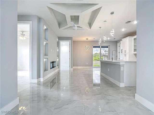 650 Kraft St, Lehigh Acres, FL 33974 - kitchen featuring ceiling fan, light marble finish flooring, white cabinetry, and baseboards