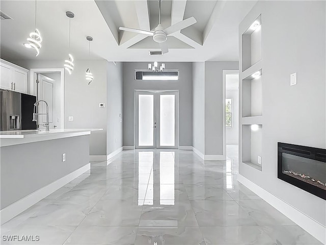 650 Kraft St, Lehigh Acres, FL 33974 - unfurnished living room with light marble finish flooring, baseboards, a ceiling fan, and a glass covered fireplace