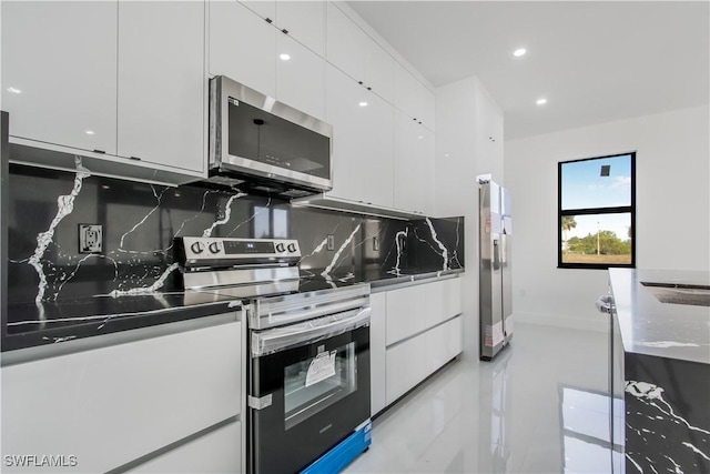 kitchen featuring white cabinetry, modern cabinets, backsplash, and stainless steel appliances