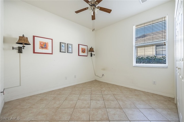 unfurnished room with light tile patterned floors, baseboards, and ceiling fan