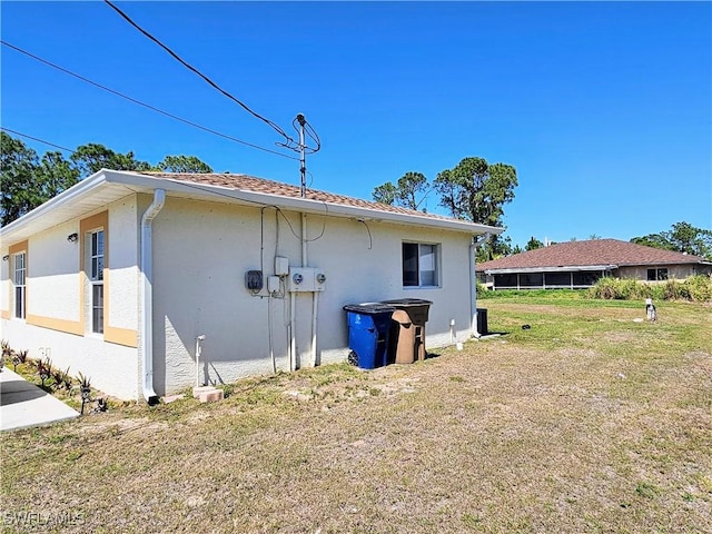 view of home's exterior featuring stucco siding and a lawn