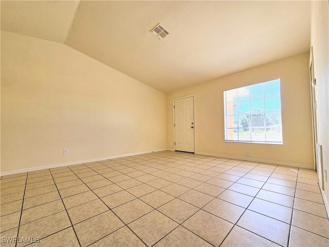 spare room with vaulted ceiling, light tile patterned floors, baseboards, and visible vents