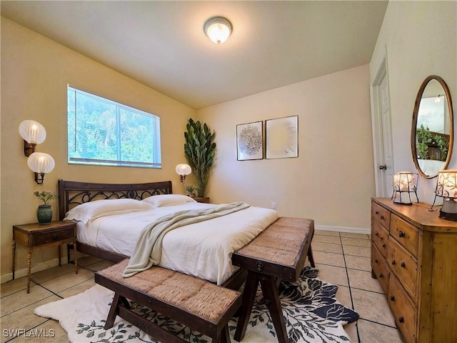 bedroom featuring light tile patterned floors and baseboards