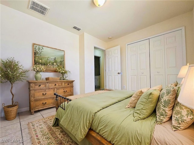 bedroom featuring light tile patterned floors, visible vents, and a closet