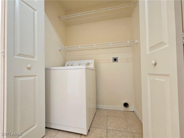 clothes washing area with light tile patterned floors, laundry area, washer / clothes dryer, and baseboards