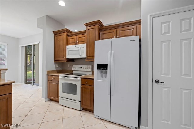 kitchen with white appliances, brown cabinetry, light tile patterned flooring, recessed lighting, and light countertops