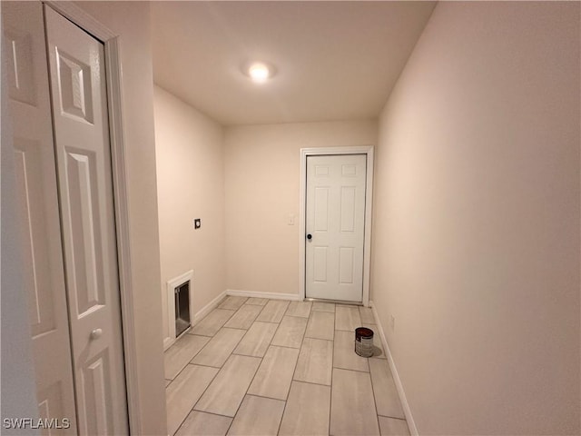 laundry room featuring baseboards and wood tiled floor