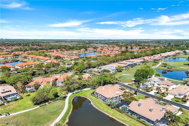 drone / aerial view with view of golf course, a water view, and a residential view