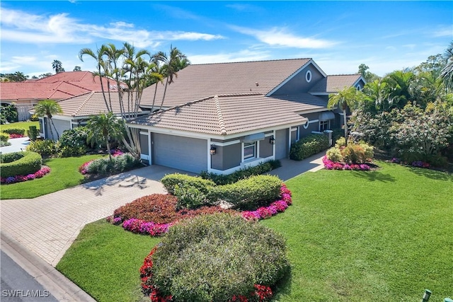 view of front of property featuring stucco siding, a tiled roof, driveway, and a garage