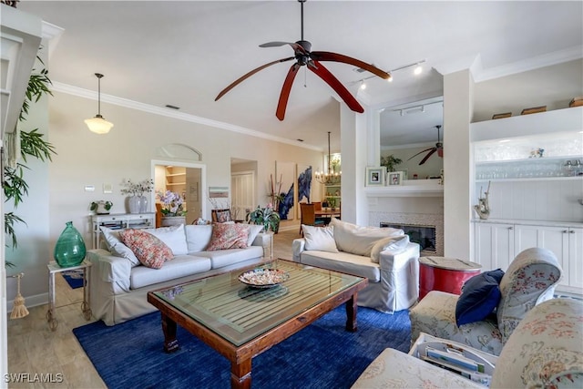 living area featuring visible vents, crown molding, baseboards, a glass covered fireplace, and ceiling fan