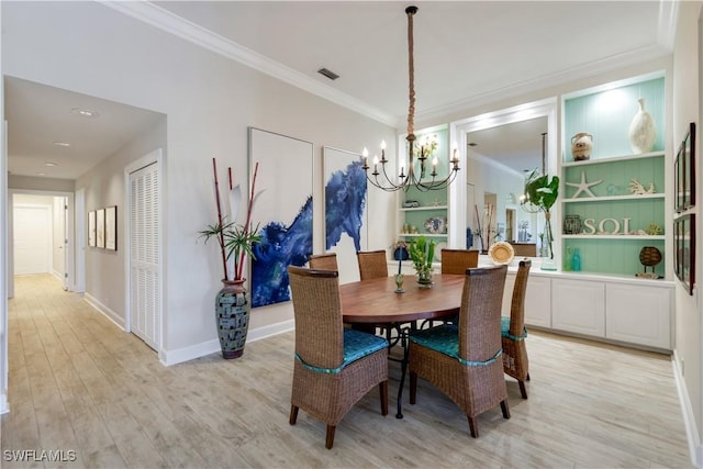 dining room featuring light wood finished floors, visible vents, ornamental molding, baseboards, and a notable chandelier