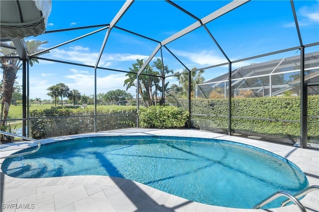 outdoor pool featuring glass enclosure and a patio