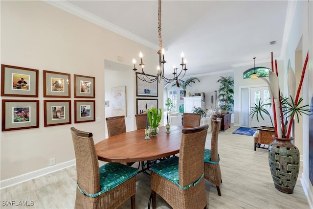 dining room with light wood-style flooring, visible vents, ornamental molding, and an inviting chandelier