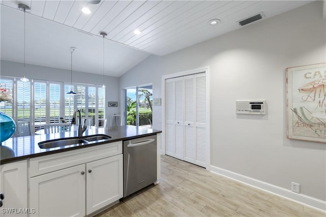 kitchen with lofted ceiling, dark countertops, visible vents, stainless steel dishwasher, and a sink
